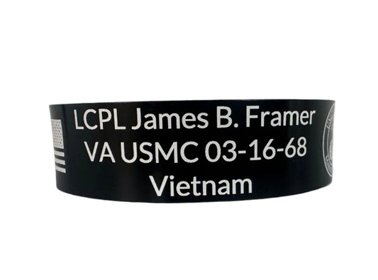 Black wristband with white text displaying military information on a white background