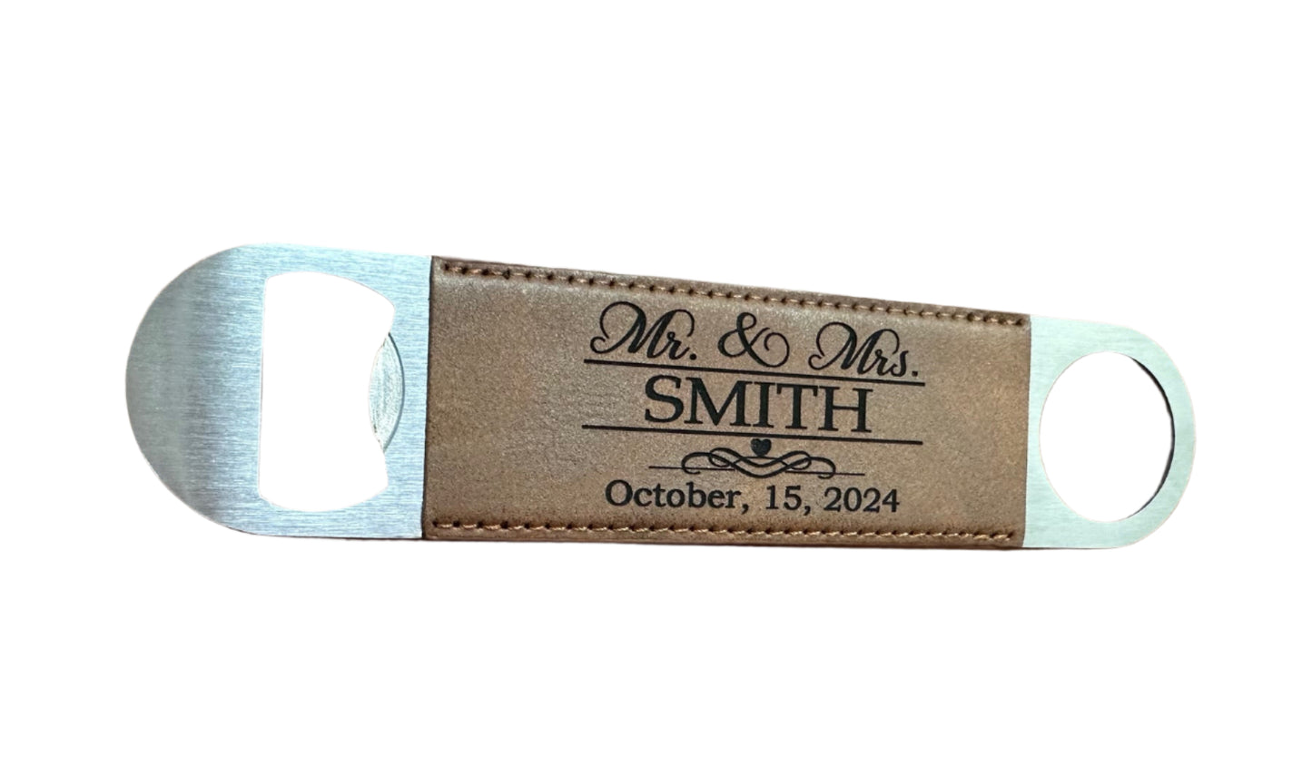 Bottle opener with leather strap personalized with 'Mr. & Mrs. Smith' and a date on a wooden surface.