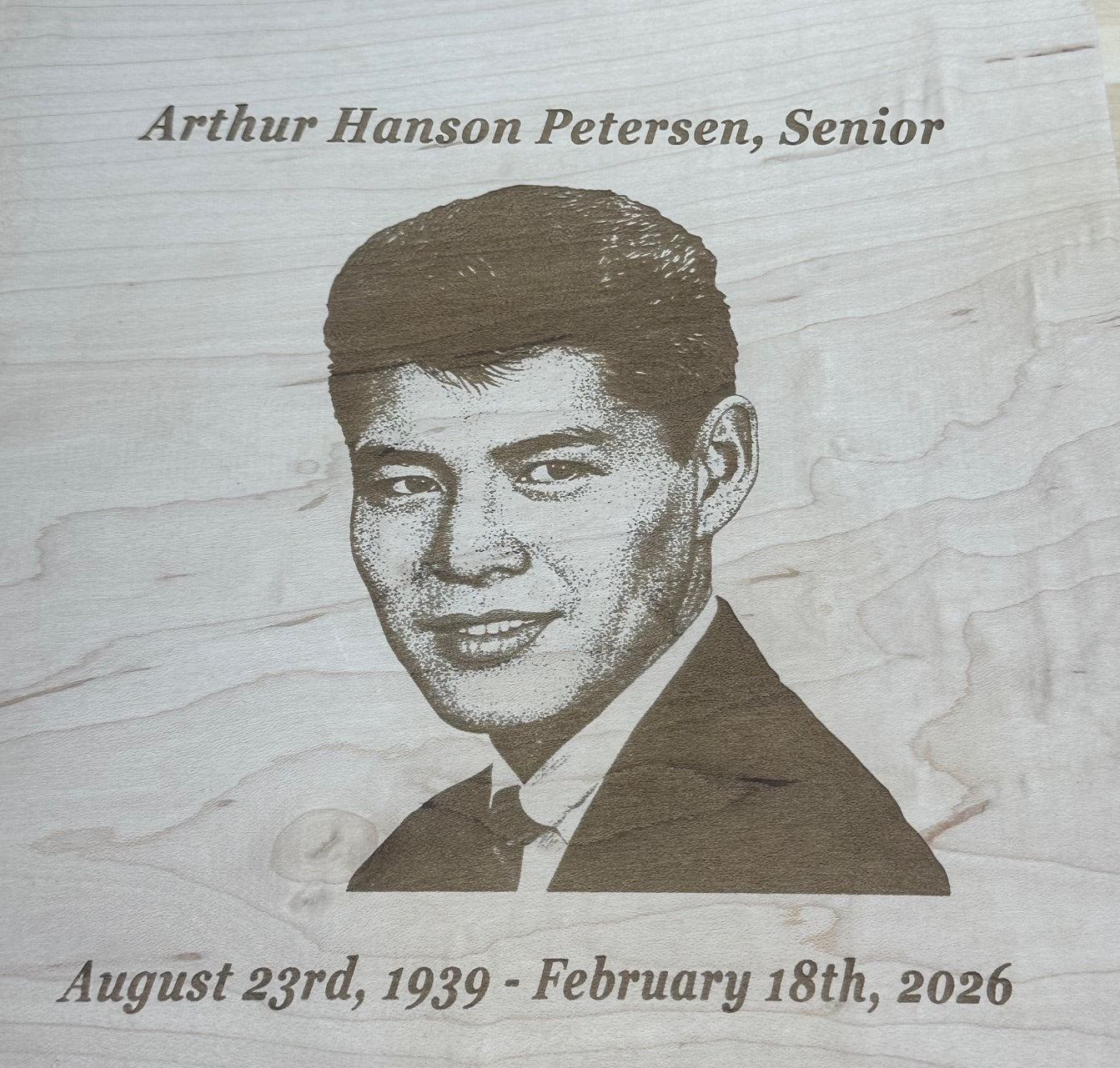 Memorial plaque with engraved portrait and details.